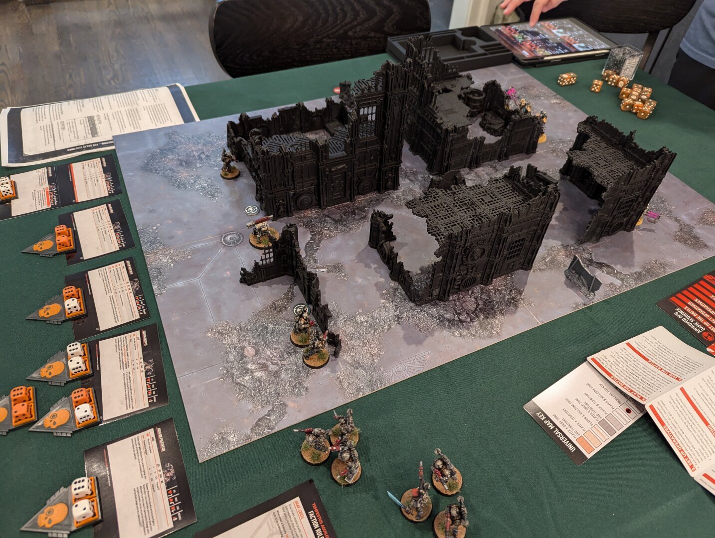 A game of Warhammer40k Kill Team. Necrons and Tempestus square off in the ruins.